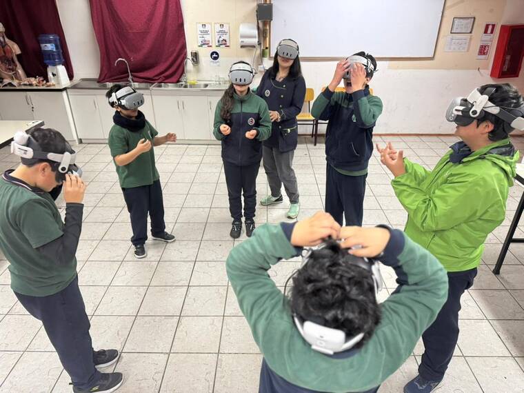 Estudiantes usando visores de realidad virtual en sala de clases
